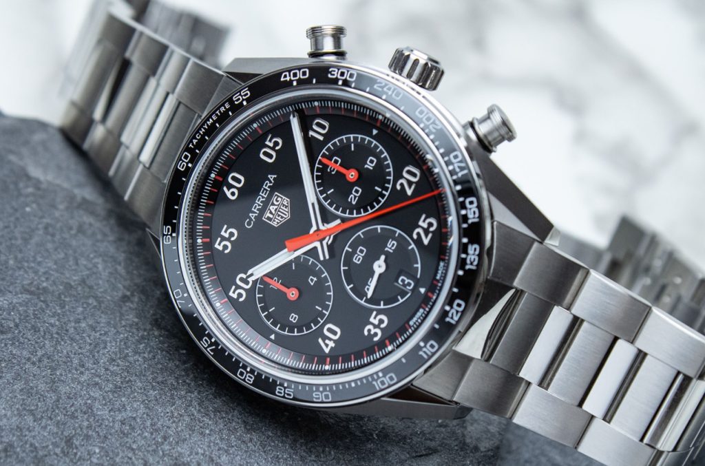 Close-up of a black Carrera Sport style chronograph dial with red accents